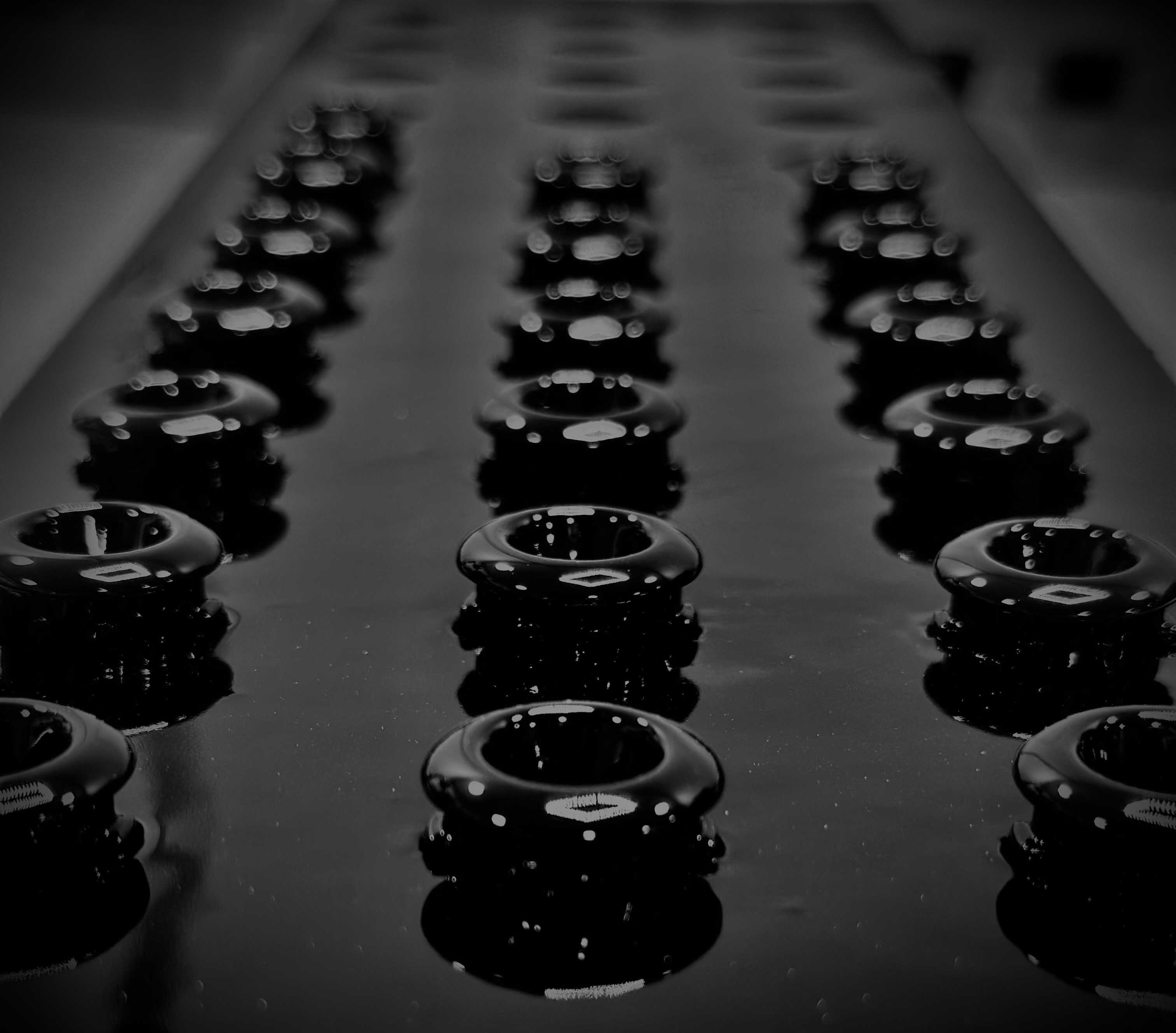 Rows of gloss black moulded escutcheons on the finishing line
